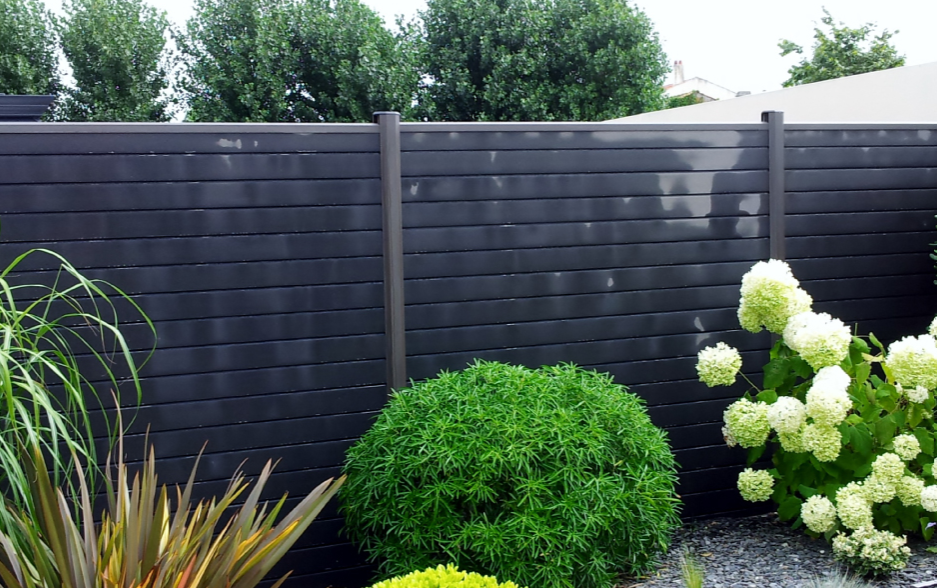 Anthracite panel fence bordered with hydrangeas and shrubs