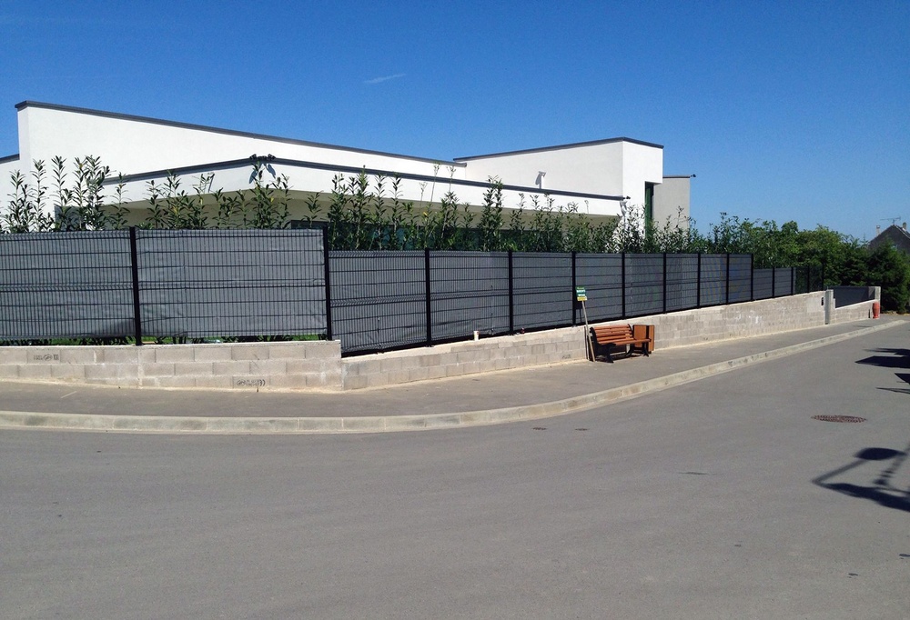 Fence with an anthracite privacy screen along a street